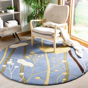 Azure Meadow luxury hand tufted round botanical rug featuring abstract wildflowers and tall grass in ivory, golden beige and olive on a soft sky blue background handcrafted from premium New Zealand wool by Indian Carpets.