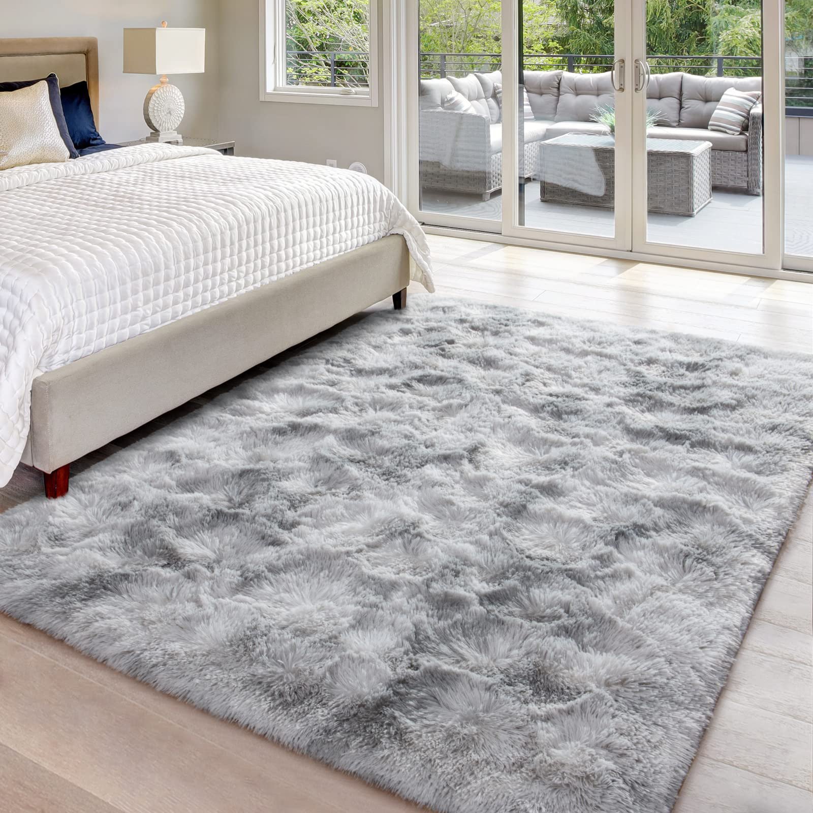Soft fluffy rug under a bed in a modern bedroom.