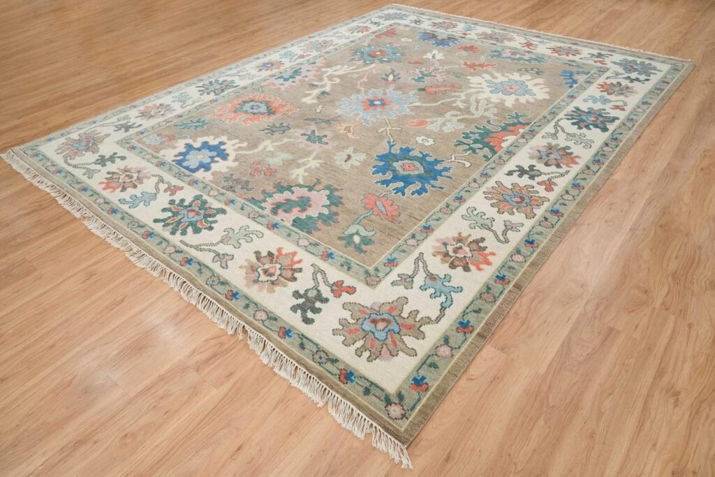 Handmade Oushak rug with soft floral motifs, muted pastel colors, and traditional artisan craftsmanship