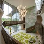 Irregular green modern rug with sculptural curved edges, cream foundation and expressive organic pattern