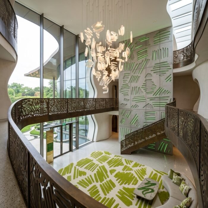 Irregular green modern rug with sculptural curved edges, cream foundation and expressive organic pattern